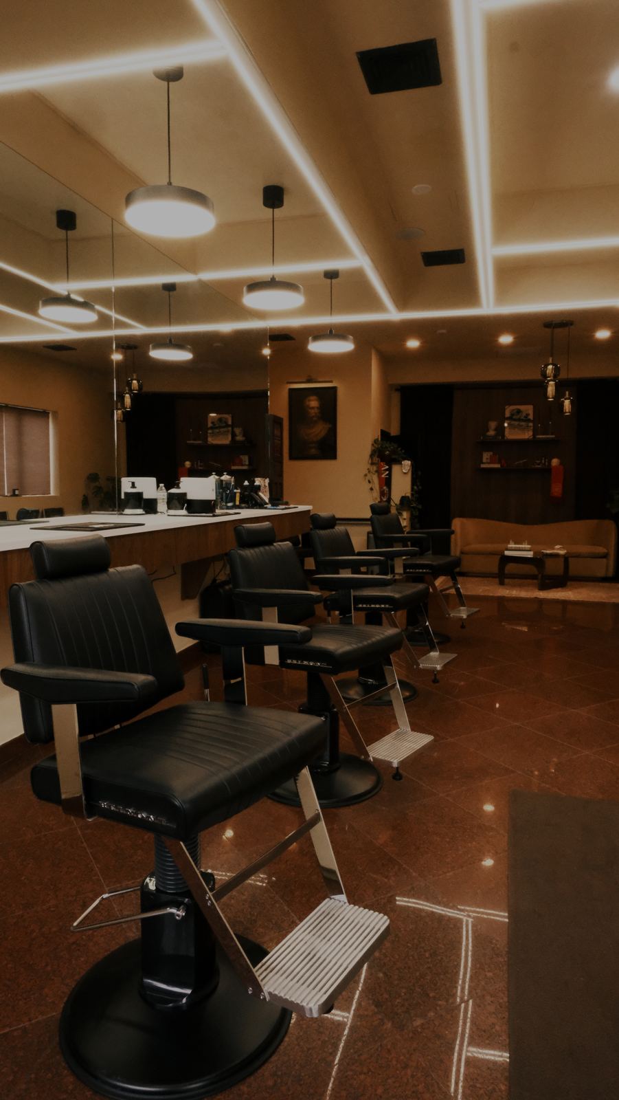 Inside Maison95 Studios — black leather barber chairs under warm lighting